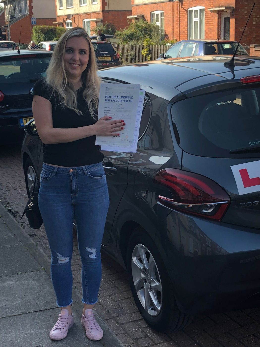 Learner driver celebrating passing her practical driving test in Leicester