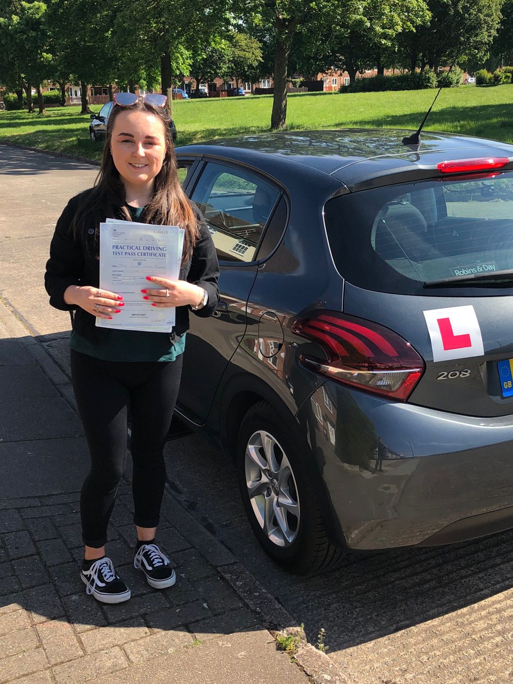 Learner celebrating her driving test pass beside Ian's tuition car